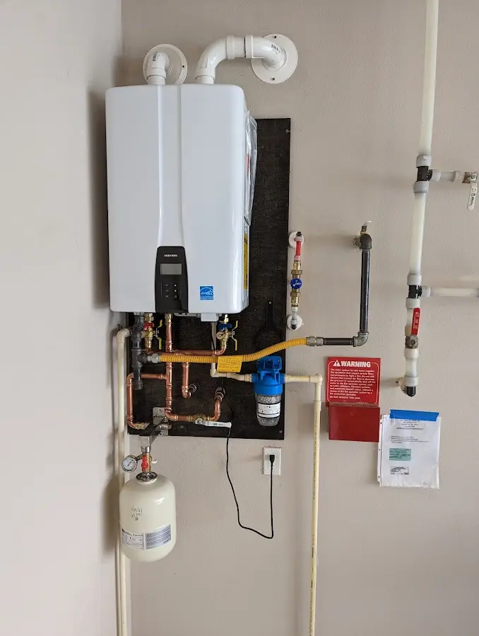 Professional plumber installing copper piping in a Olga home